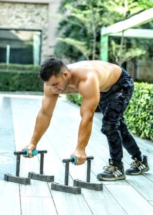 Heavy-duty parallel push-up bars in black with ergonomic grips and a non-slip base for strength training and calisthenics.