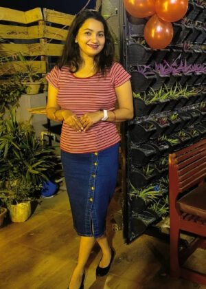 Navy blue straight long denim skirt for women with a button and zip closure, styled with a white top.